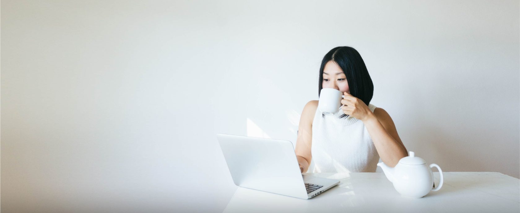 Woman drinking tea with a laptop